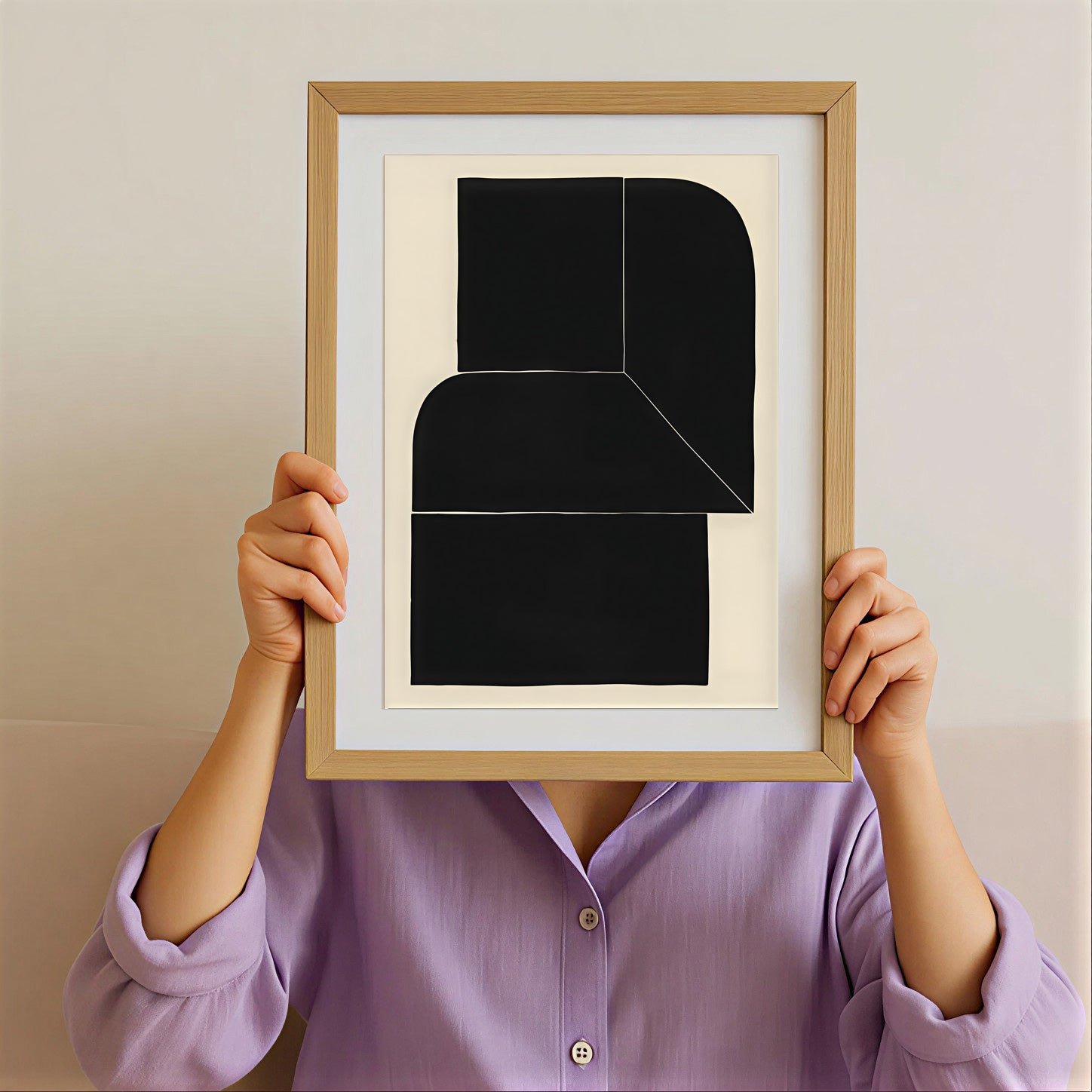 Person holding a framed abstract art piece with a plain background