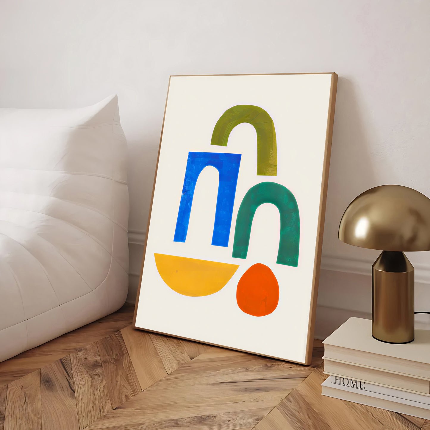 Colorful abstract art print on a wooden floor with a lamp and books in the background